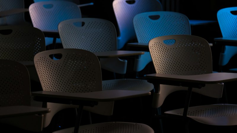 Rangées de chaises d'examen vides, avec tablettes écritoires