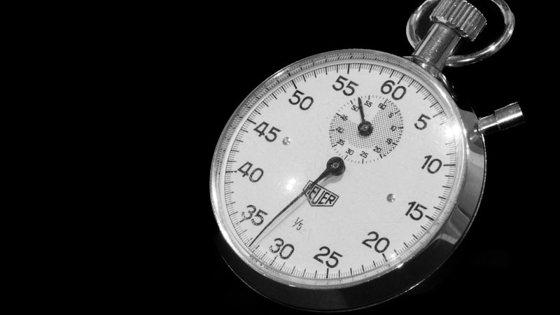 Chronomètre mécanique posé sur une surface sombre