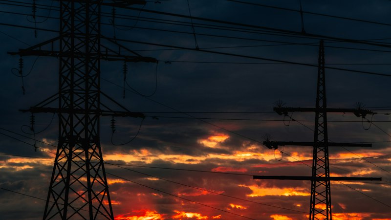 Lignes électriques en silhouette sur un ciel de coucher de soleil